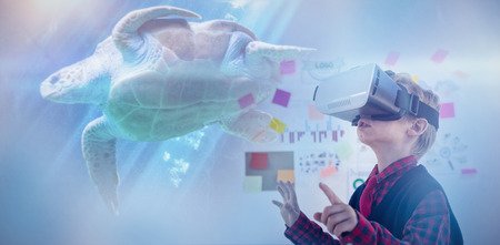 Sea turtle swimming with fish in tank against businessman wearing virtual reality simulatorの写真素材