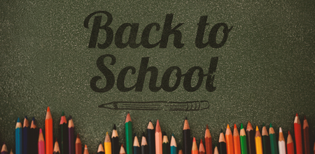 Back to school text over white background against overhead view of colored pencils on gray tableの写真素材