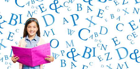 Portrait of girl holding pink book against lettersの写真素材
