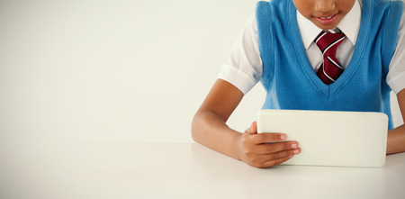 Schoolboy using digital tablet against white backgroundの写真素材