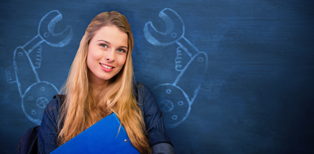 Pretty student in the library against blue backgroundの写真素材