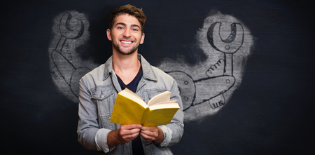 Student smiling at camera in library against black backgroundの写真素材