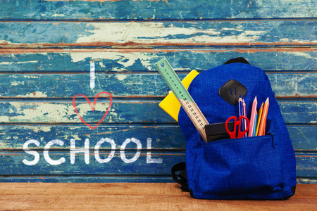 I love school text on white background against school bag on tableの写真素材