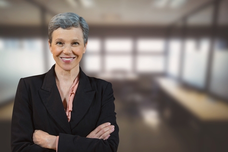 Digital composite of Happy business woman standing against office backgroundの写真素材