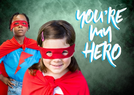 Digital composite of You're my hero text with Superhero kids in front of green backgroundの写真素材