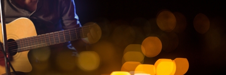 Digital composite of Man playing guitar with yellow lightsの写真素材