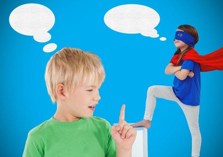 Digital composite of Boy and superhero girl with blue background and speech bubblesの写真素材