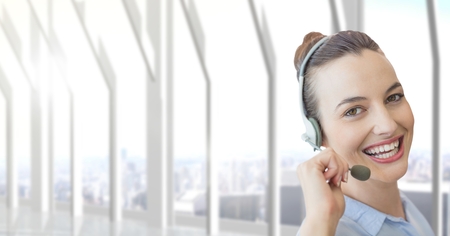 Digital composite of Happy customer care representative woman against city backgroundの写真素材