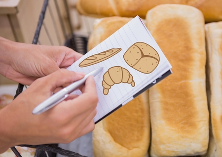 Digital composite of Drawing bread on notepad with bread in backgroundの写真素材
