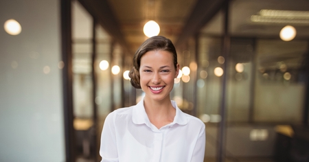 Digital composite of Happy business woman standing against office backgroundの写真素材