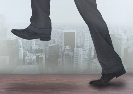 Digital composite of Businessman's legs over cityの写真素材