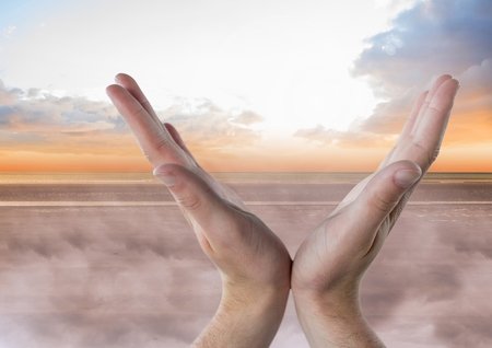 Digital composite of Hands open in V shape with skyの写真素材