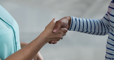 Digital composite of Business people shaking hands against grey backgroundの写真素材