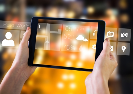 Digital composite of Holding tablet and City with icons and interface
