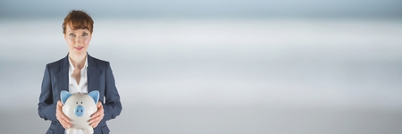 Digital composite of Woman holding a piggy bankの写真素材