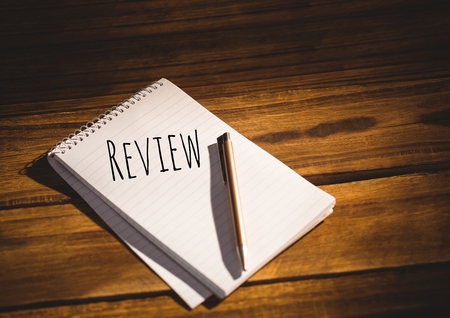 Digital composite of Review  text written on page with wood