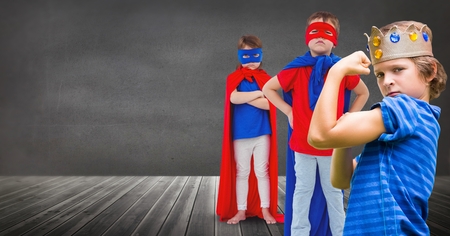 Digital composite of Superhero kids and king crown boy with blackboard backgroundの写真素材