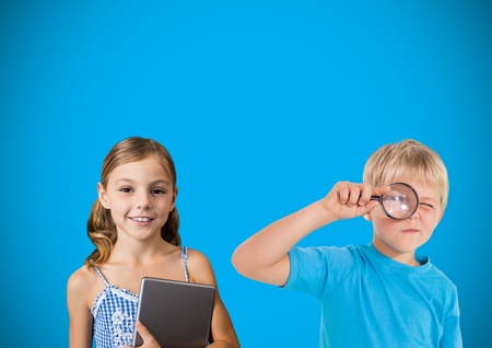 Digital composite of Kids with magnifying glass in front of blue backgroundの写真素材