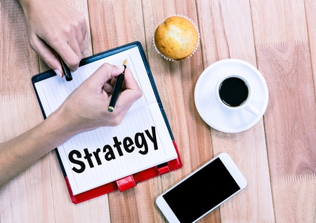 Digital composite of Strategy text written on page with coffee and phoneの写真素材