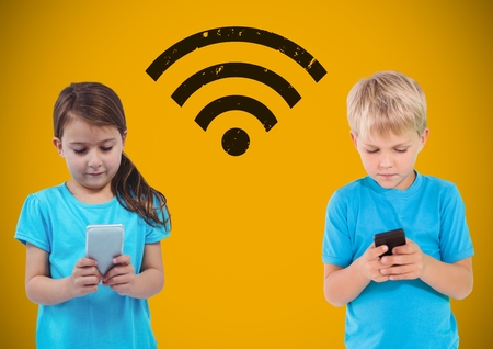 Digital composite of Texting kids with blank yellow background with wi-fi graphicの写真素材