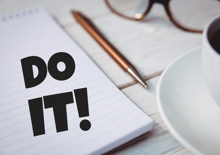Digital composite of Do It!  text written on page with glasses and pen