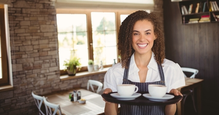 Digital composite of Happy small business owner woman holding two coffeesの写真素材
