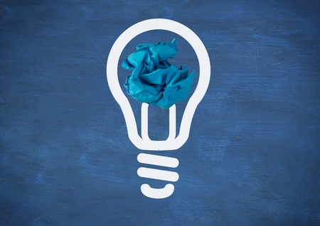 Digital composite of light bulb with crumpled paper ball in front of blackboardの写真素材