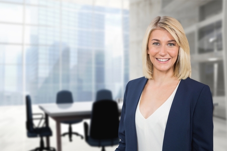 Digital composite of Happy business woman standing against office backgroundの写真素材