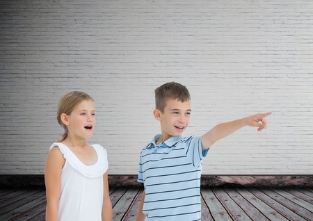 Digital composite of kids pointing surprised with blank room backgroundの写真素材