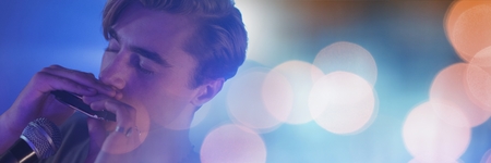 Digital composite of Man playing harmonica with yellow lightsの写真素材