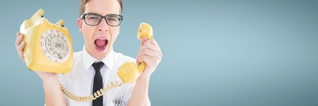 Digital composite of Angry man holding a yellow phone against blue background
