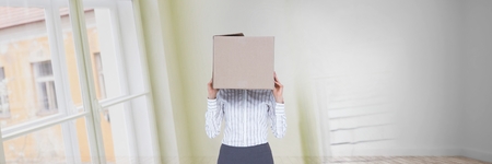 Digital composite of Woman with a box on her head standing in her new houseの写真素材