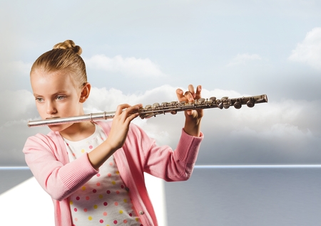 Digital composite of Girl playing the flute in front of cloudsの写真素材