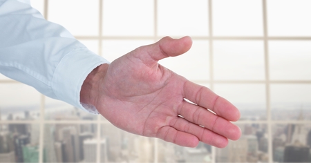 Digital composite of Business man stretching hand against city backgroundの写真素材
