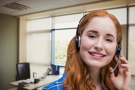 Digital composite of Happy customer care representative woman against office backgroundの写真素材