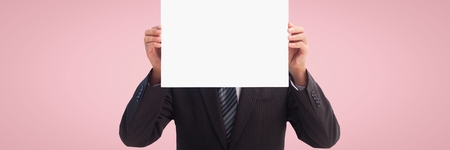 Digital composite of Business man holding a blank card against pink backgroundの写真素材