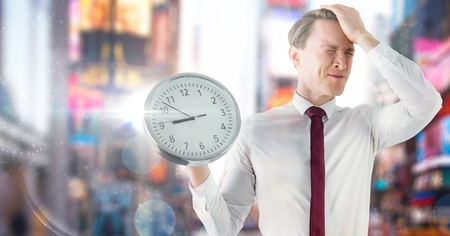 Digital composite of man holding clock in front of colorful cityの写真素材