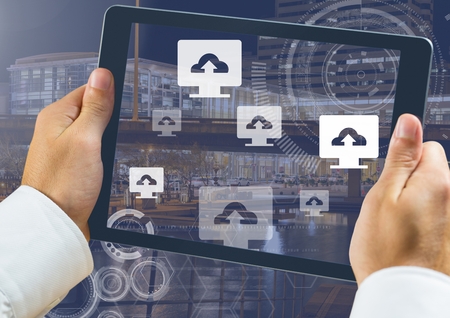 Digital composite of Holding tablet and Upload computer icons over city
