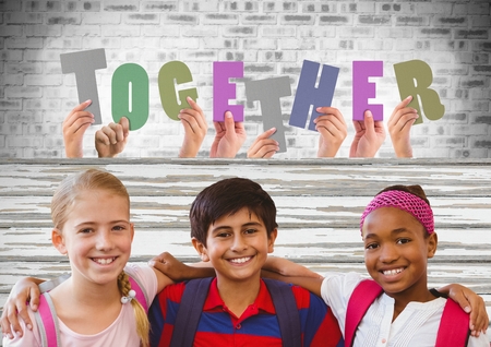 Digital composite of Together cut out letters with Kids friends together in front of brick wallの写真素材