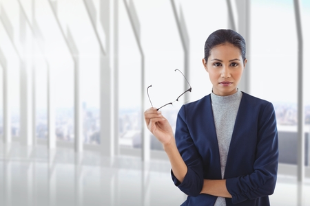 Digital composite of Business woman holding her glasses against building backgroundの写真素材