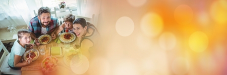 Digital composite of Overhead of family at table with orange bokeh transitionの写真素材