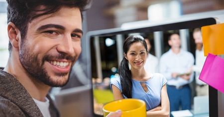 Digital composite of Businessman video conferencing with colleagues in office
