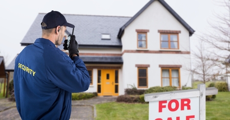 Digital composite of Security guard talking on walkie talkie while standing on roadの写真素材