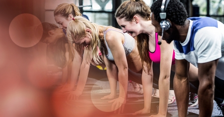 Digital composite of Athletic team doing push-ups on the floor in gymの写真素材