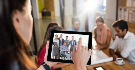 Digital composite of Female executive video conferencing with colleagues in officeの写真素材