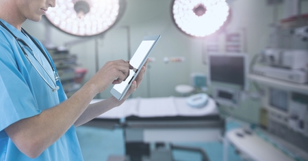 Digital composite of Doctor holding tablet in surgery operating theatreの写真素材