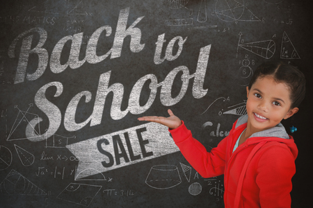 Portrait of smiling girl gesturing against white background against close-up of blackboardの写真素材