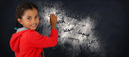 Portrait of smiling girl holding chalk against black backgroundの写真素材