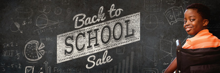 Portrait of cute boy sitting in wheelchair against close-up of blackboard