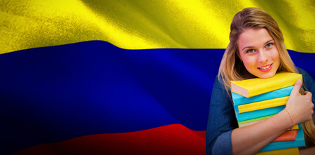 Pretty student in the library against digitally generated colombia national flagの写真素材